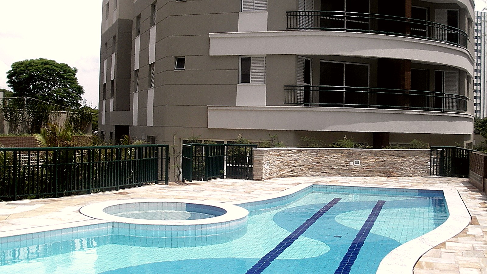 Piscina com solário e jardim na área de lazer do Residencial Villa Splendore, Alto de Pinheiros, São Paulo